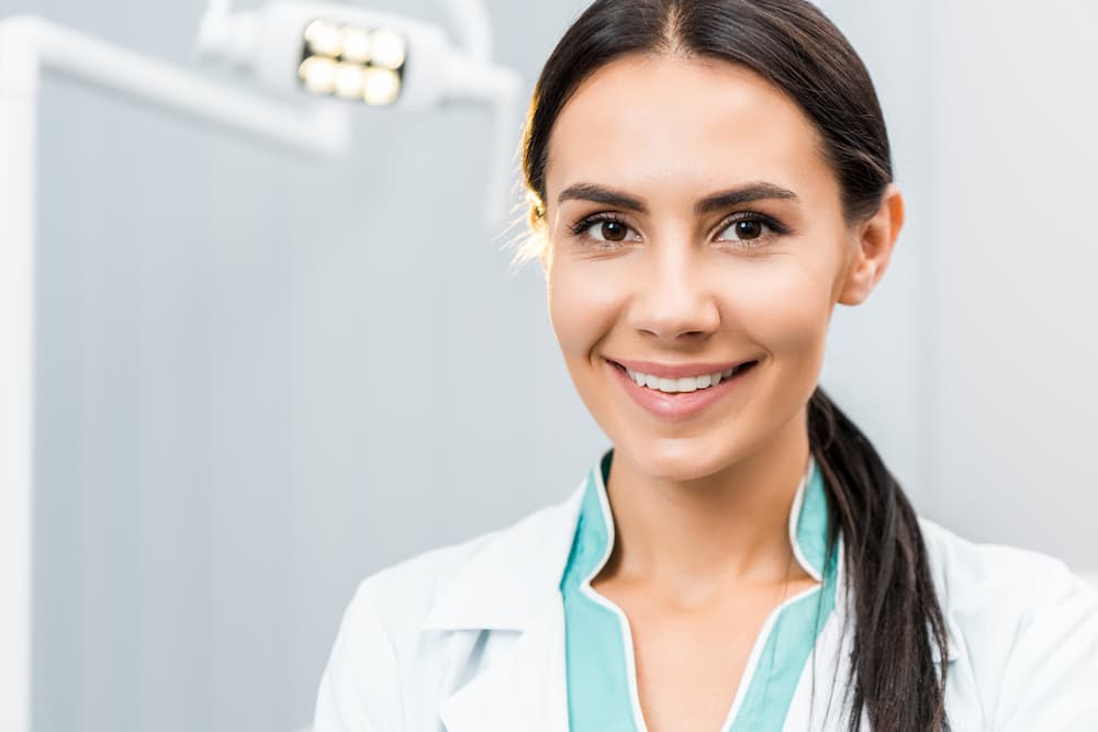 close-up-of-smiling-female-dentist-in-dental-clini-HTPVJXB (1)